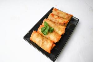 Lumpia or lunpia, is traditional spring roll skin snack from Semarang, Indonesia. Traditional Spring rolls made eggs, and chicken or shrimp, stir-fried bamboo shoots. isolated on white background photo