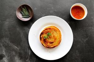 pan paratha o pan canai o roti maryam, plato de desayuno favorito. servido en plato foto