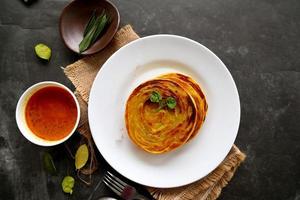 paratha bread or canai bread or roti maryam, favorite breakfast dish. served on plate photo