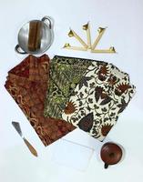 flat lay batik clotes with canting, small pan and wax earthenware glass isolated on white background photo