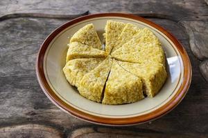 Krasikan is traditional food snack from java made glutinous rice, coconut milk, brown sugar, grated coconut, teaspoon of betel lime water served wood background photo