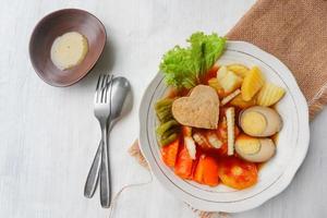 selat solo is traditional salad food from indonesia. made from hard-boiled eggs, boiled chickpeas, boiled carrots, hash browns and lettuce, steak or bistik. served on wood table photo