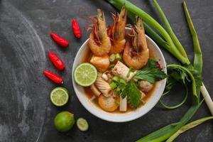 Tom yam soup originating from Thailand. Tom yum is made with shrimp, chili, lime, chicken, fish, or seafood and mushrooms. photo