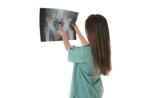 joven doctora mirando la imagen de rayos x. aislado en blanco foto