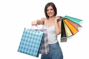 Image of a beautiful young brunette lady posing with shopping bags and looking at camera. shopping concept. Isolated photo