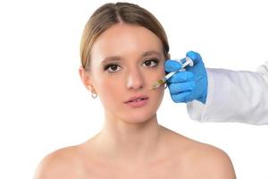 young woman gets injection of botox in her face. Woman in beauty salon. plastic surgery clinic. photo