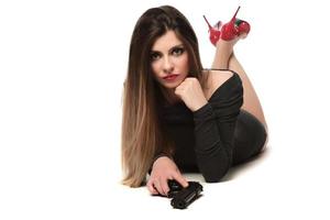 beautiful female with red high hills holding a gun. isolated photo