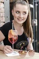 young woman drinking cocktail at bar counter. photo