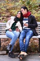 Mixed couple In park enjoying each other and drinking coffee photo