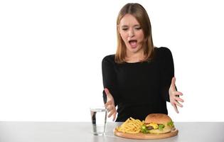 retrato de una hermosa joven divertida comiendo hamburguesa foto