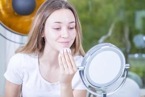 young beautiful woman cleans her face with wet wipes. isolated photo