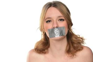 scared young woman with tape over her mouth. photo