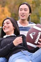 mixed Couple In Park playing American Football. American football. Couple playing Rugby. photo
