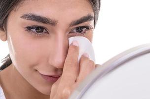 Young beautiful woman cleaning her face with cotton pads photo