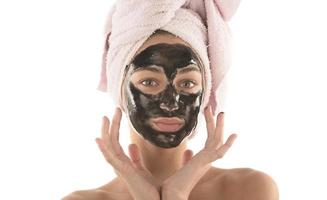 Beautiful girl with black facial cosmetic mask. Beauty concept. isolated photo