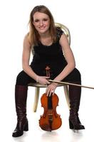 hermosa chica rubia natural sosteniendo y tocando el violín. foto