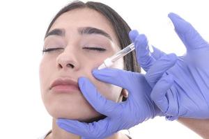 mujer joven recibe inyección de botox. inyección antienvejecimiento foto