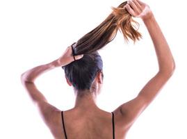 back view of young woman tied her hair in bun. isolated photo