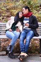 Mixed couple In park enjoying each other and drinking coffee photo