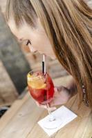 young woman drinking cocktail at bar counter. photo