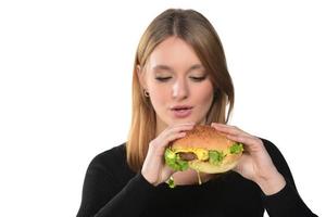 retrato de una hermosa joven divertida comiendo hamburguesa foto