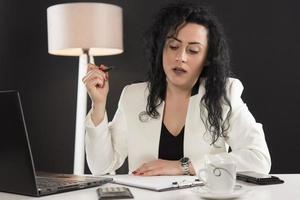 happy business woman trying to work in her office photo