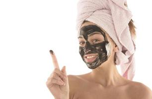 Beautiful girl with black facial cosmetic mask. Beauty concept. isolated photo