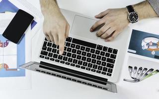 manos escribiendo en una computadora portátil en un escritorio de oficina. concepto de negocio foto