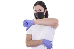 Asian male model wearing and holding surgical face mask and protective gloves photo