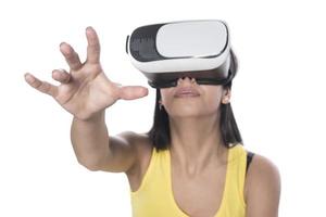 linda mujer emocionada con auriculares vr mirando hacia arriba y tratando de tocar objetos en la realidad virtual foto