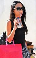 Beautiful woman walking on the street with shopping bags. Trendy female model in the city holding shopping bags. photo