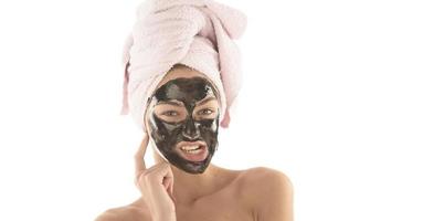 Beautiful girl with black facial cosmetic mask. Beauty concept. isolated photo