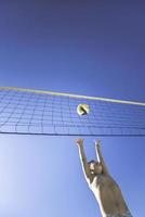 Kid plays volleyball on beautiful summer day photo