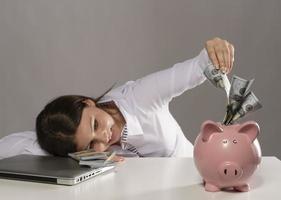 saving concept. beautiful female model saving her money in a piggy bank photo