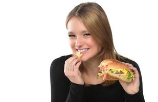 portrait of a beautiful funny young girl eating hamburger. photo