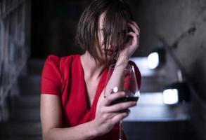 female fashionable model holding glass and bottle of wine. Woman driking wine. photo