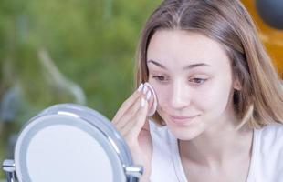 young beautiful woman cleans her face with wet wipes. isolated photo