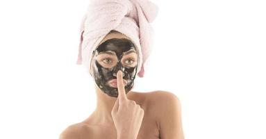 Beautiful girl with black facial cosmetic mask. Beauty concept. isolated photo