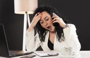 beautiful business woman sitting in her office and talking on the cellphone. business concept photo