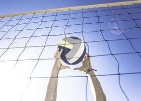 Kid plays volleyball on beautiful summer day photo