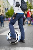 Electric unicycle. Man rides on mono wheel on zebra crossing photo