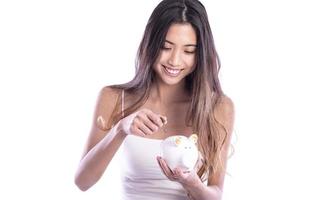 Asian woman saving money in piggy bank photo