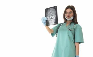 Young female doctor looking at the x-ray picture. isolated on white photo