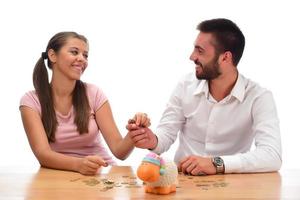 Family savings concept. Beautiful couple home financing. Saving money in the piggy bank. photo