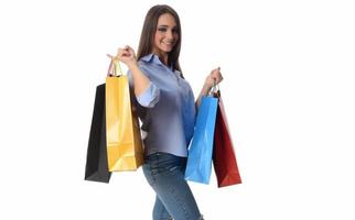 concepto de compras. hermosa morena sonriente con bolsas de compras posando sobre fondo blanco foto