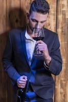 man holding and drinking wine photo