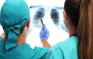 los médicos examinan la radiografía de los pulmones del paciente covid 19. aislado sobre fondo blanco. covid 19, sars cov 02, concepto foto