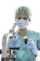 científico con guantes médicos azules y muestras uniformes de aprendizaje covid-19 con microscopio en laboratorio. foto