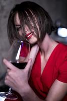 mujer sosteniendo una copa de vino tinto foto