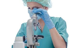 científico con guantes médicos azules y muestras uniformes de aprendizaje covid-19 con microscopio en laboratorio.